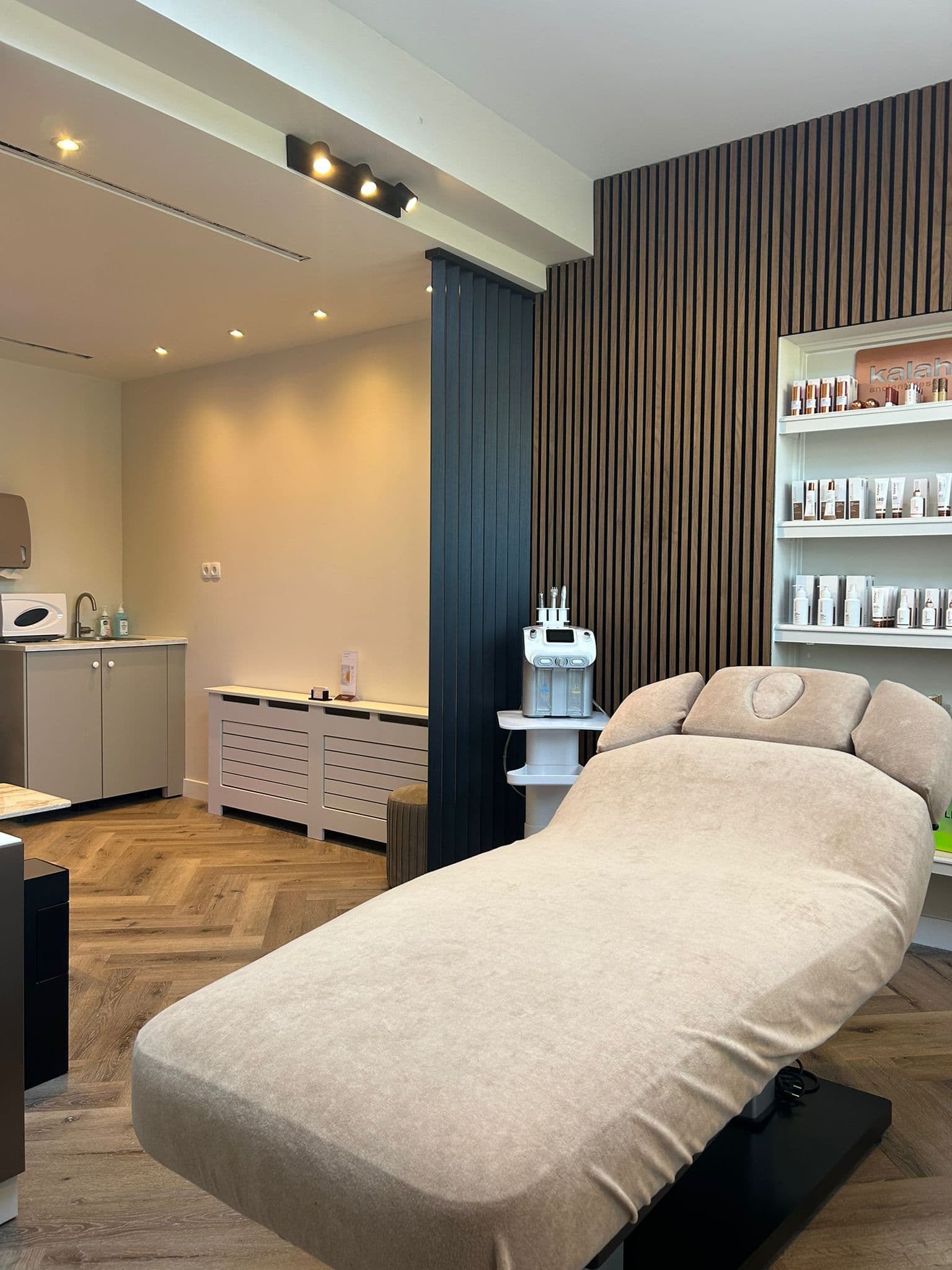 Interieur van Skinstudio Zuid met visgraatvloer en latjeswand